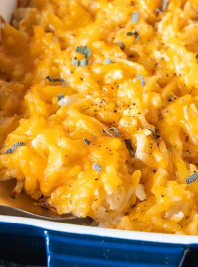 close up view of spoon in cheesy potatoes