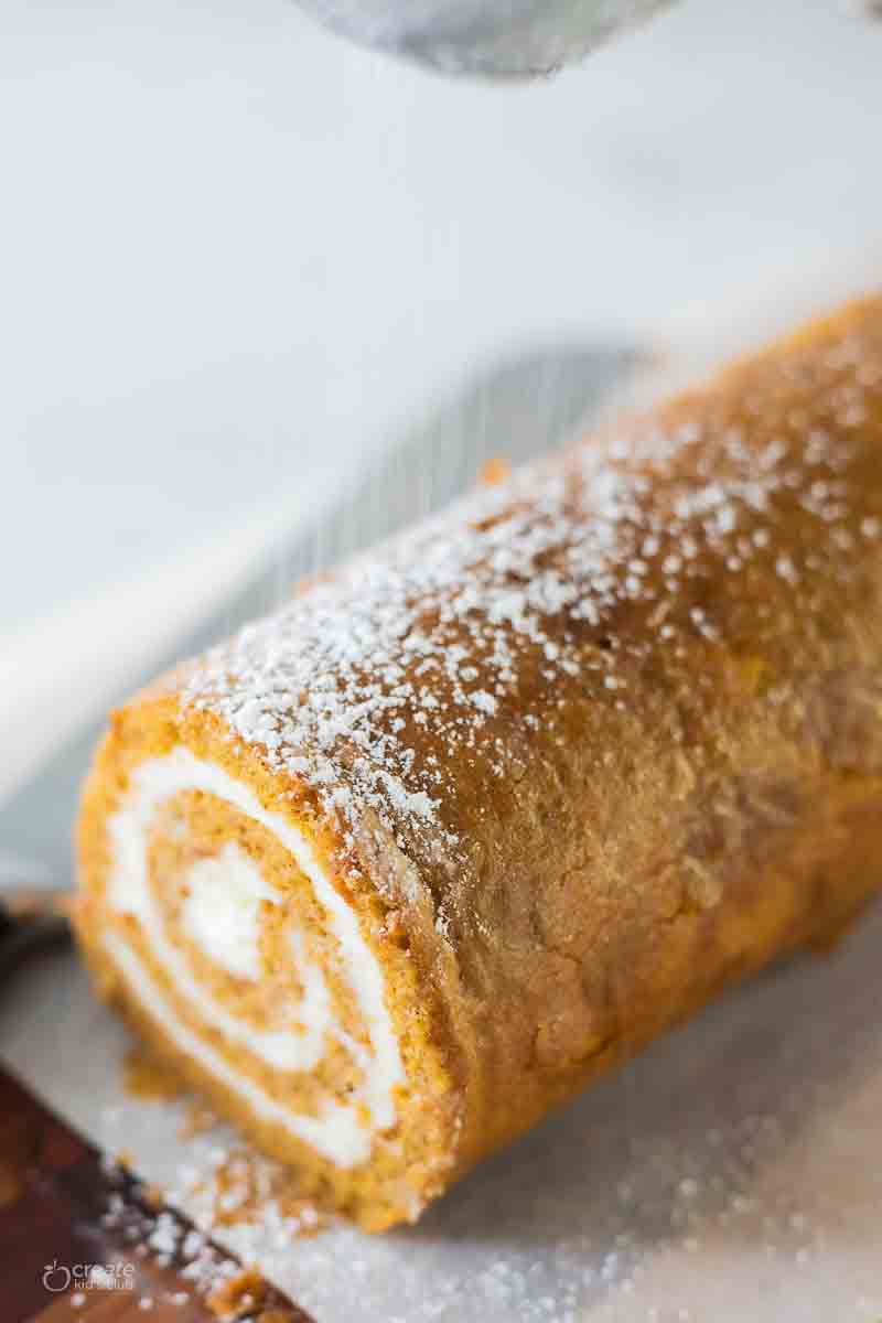 pumpkin roll on top of parchment paper