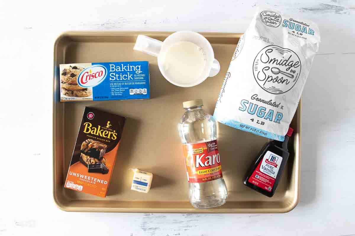shortening, milk, sugar, vanilla, corn syrup, butter and chocolate bar on a sheet pan