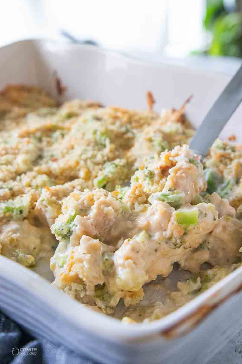 spoon scooping a serving of chicken casserole from baking dish