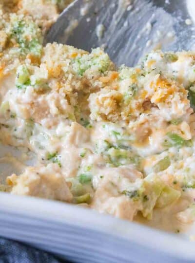 chicken casserole being scooped from baking dish