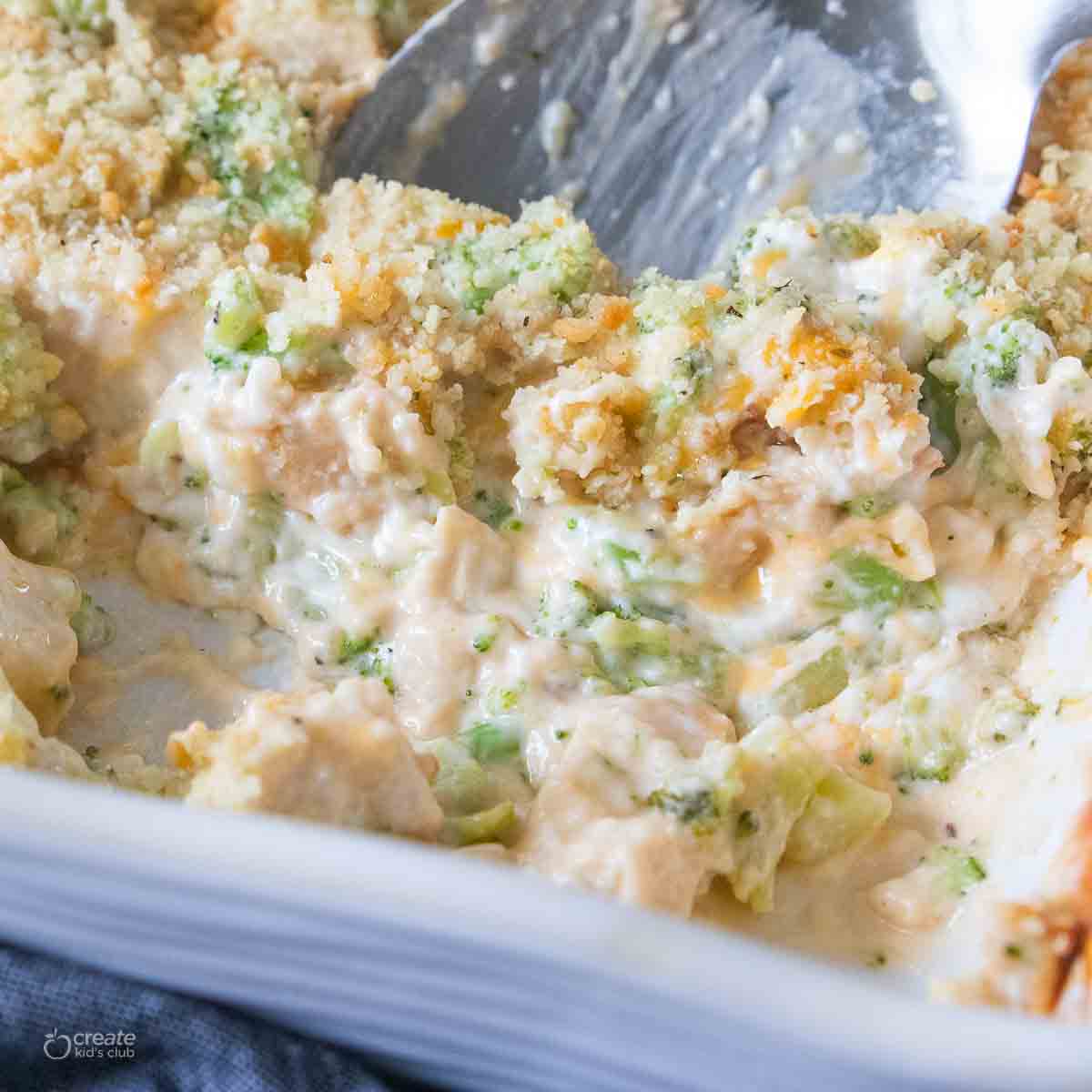 chicken casserole being scooped from baking dish