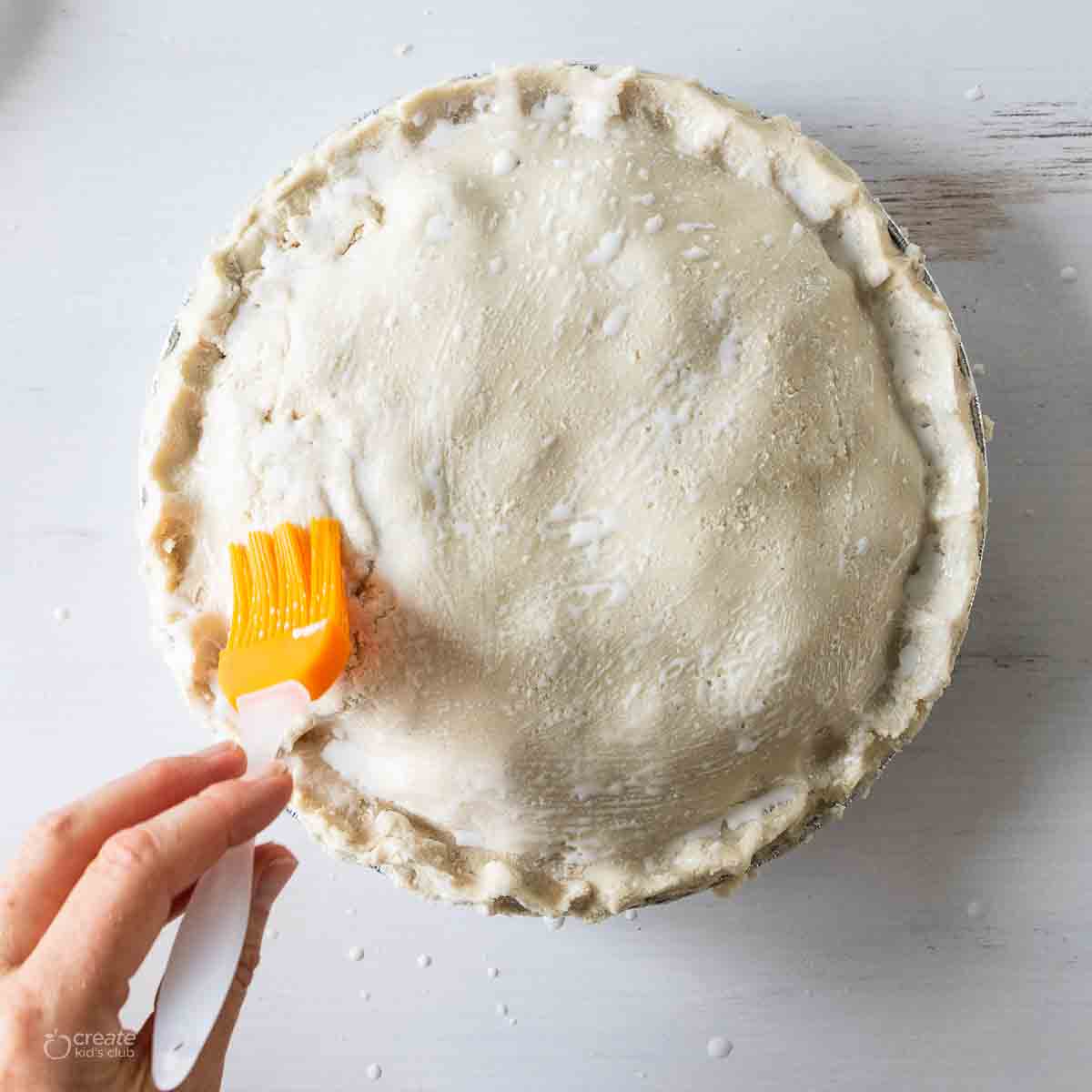 gluten free dough added to top of pie crust and brushed with milk