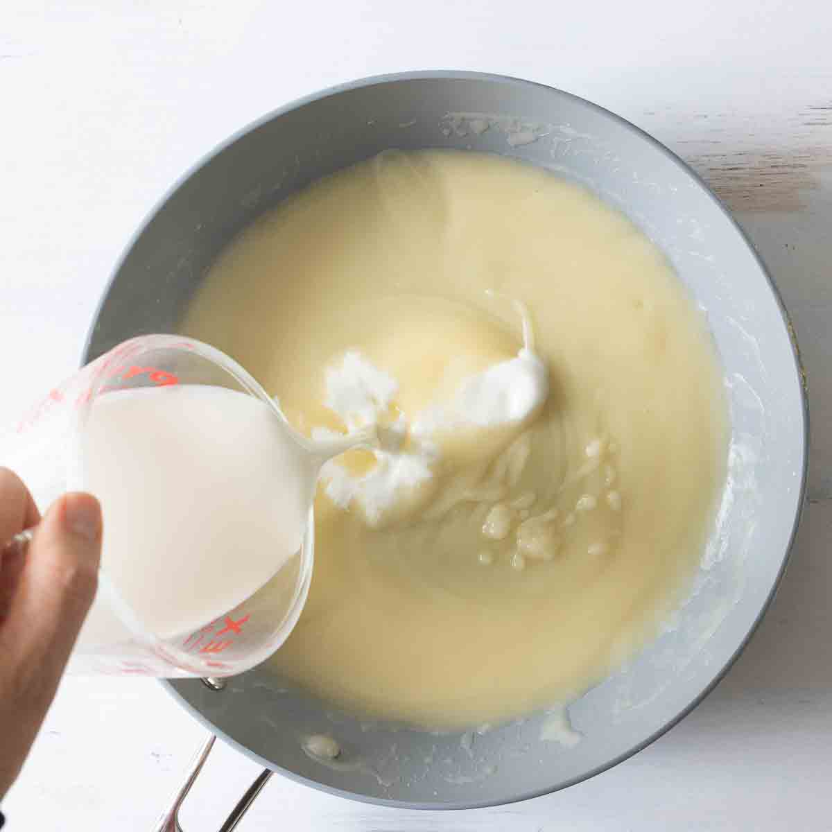 milk slowly poured into hot cornstarch roux