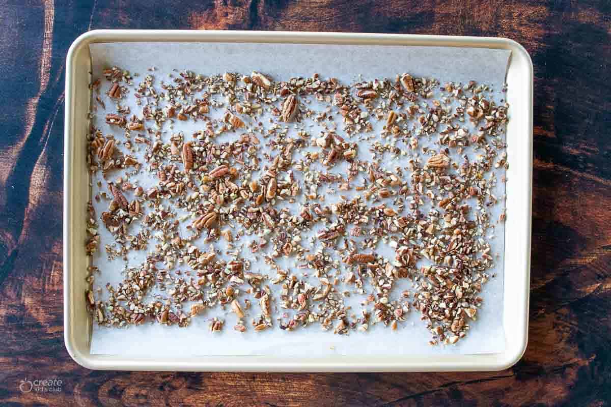 toasted crushed pecans on parchment lined baking sheet