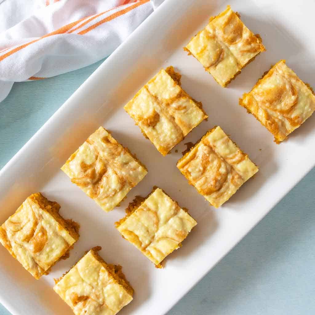 Gluten free pumpkin bars cut into squares on a white tray.