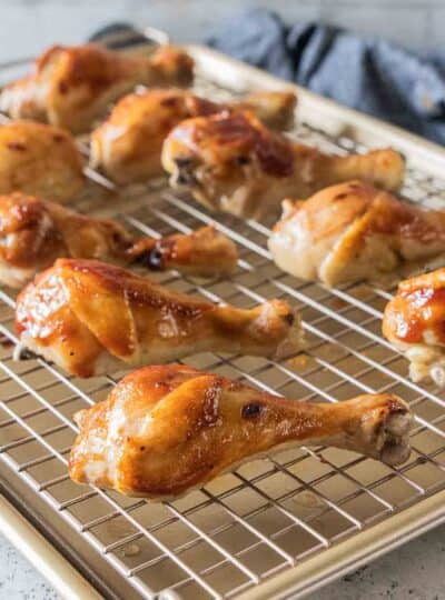 boiled chicken legs on wire rack on top of baking sheet