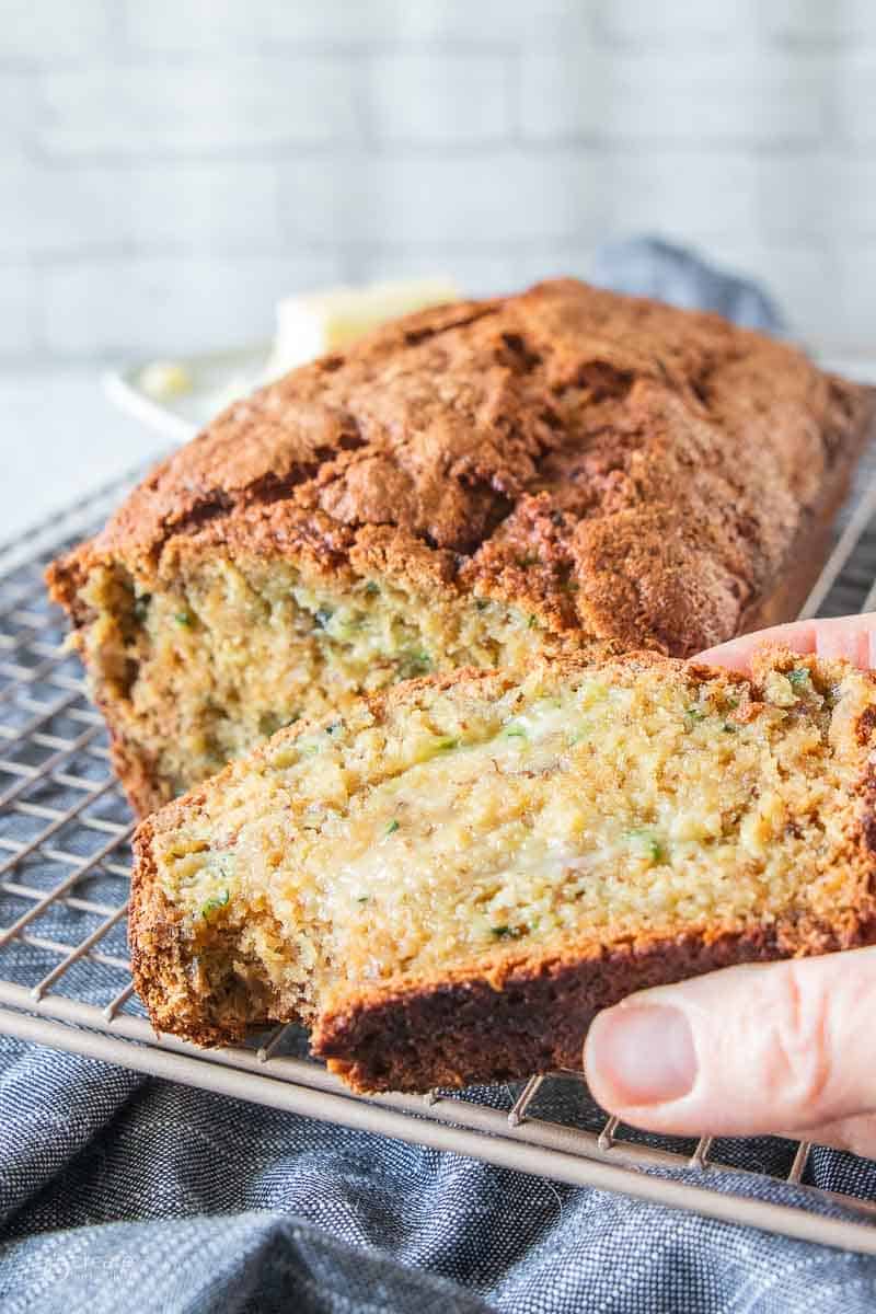 hand holding a slice of zucchini bread