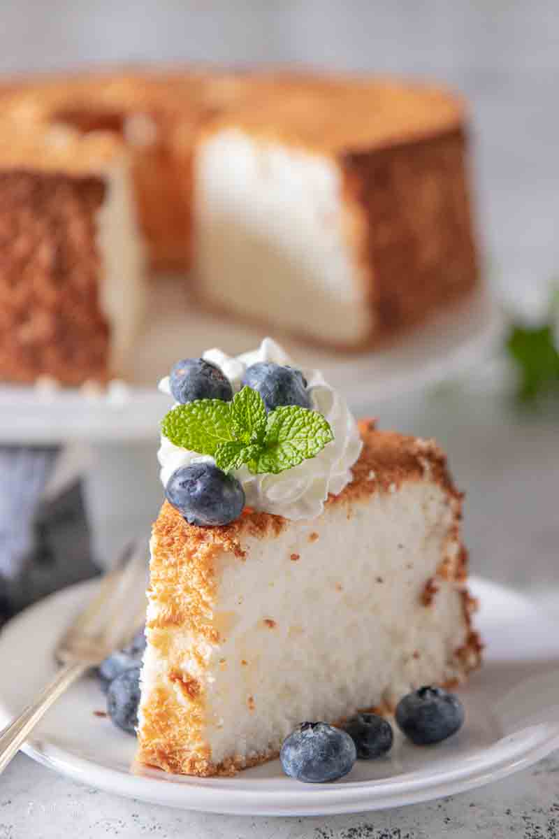 slice of angel food cake topped with whipped cream and berries