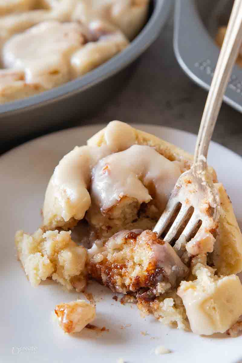 fork scooping a bite of a gluten free cinnamon roll