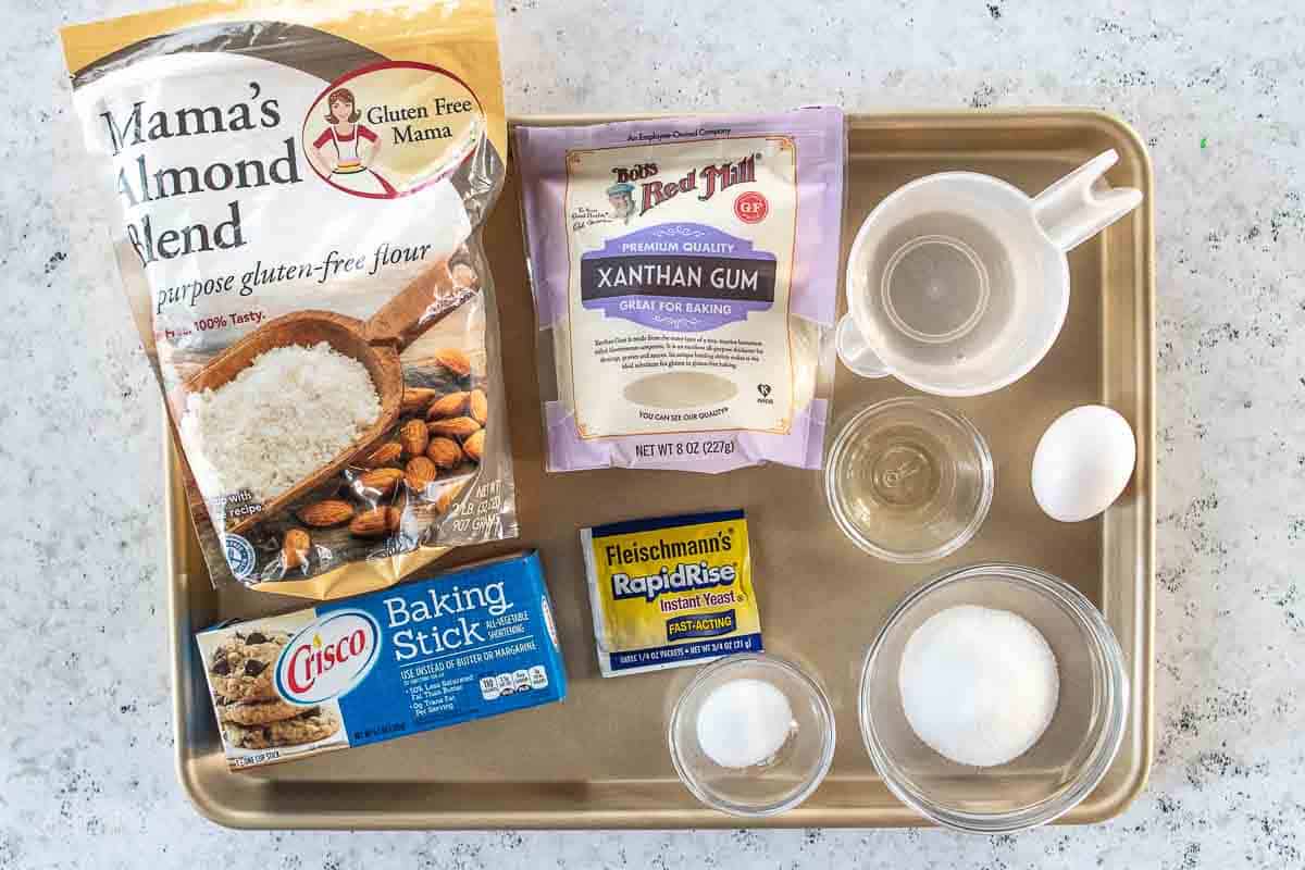 almond flour, xanthan gum, baking stick, yeast and various other ingredients for dinner rolls on baking sheet
