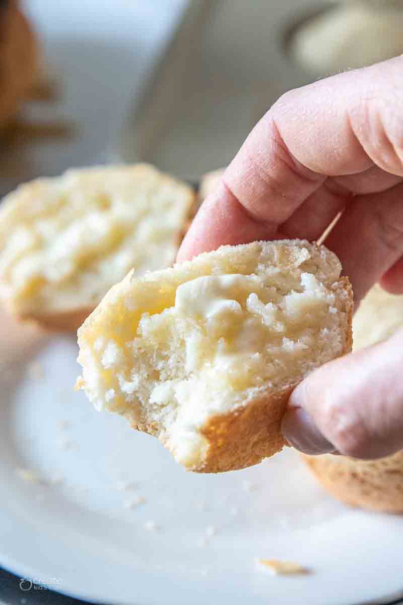 piece of dinner roll held in a hand