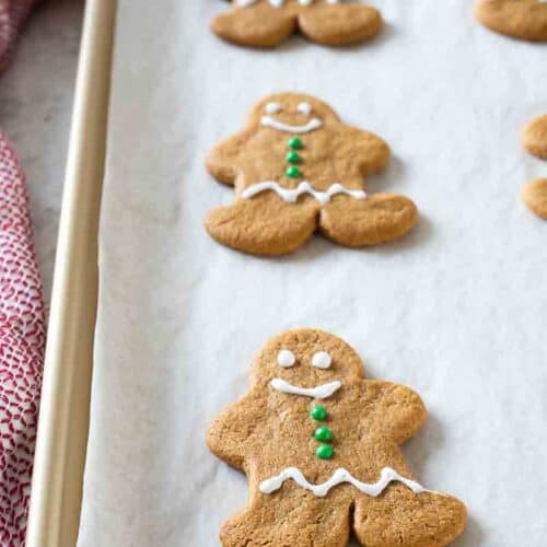 iced gingerbread cookie on parchment lined baking sheet