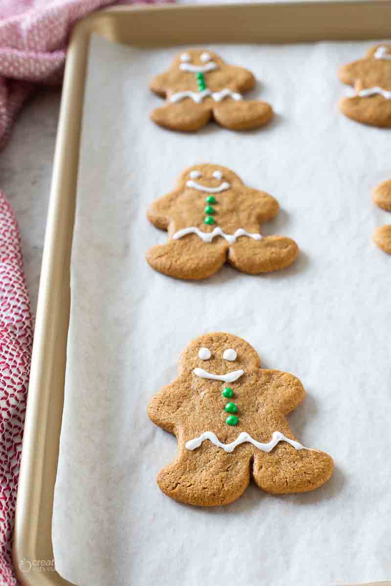 iced gingerbread cookie on parchment lined baking sheet