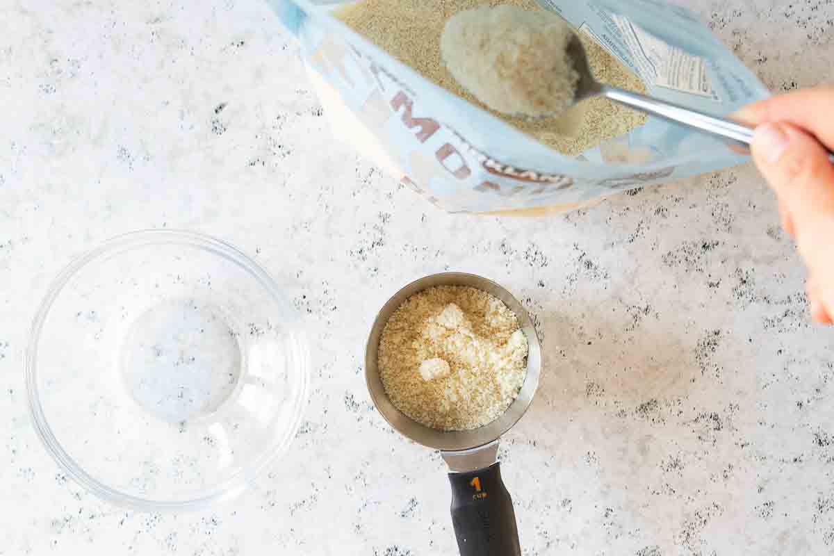 almond flour scooped from bag into measuring cup