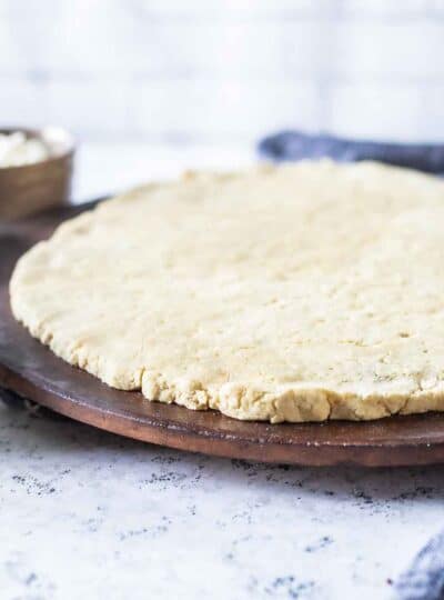 gluten-free pizza dough on a pizza stone