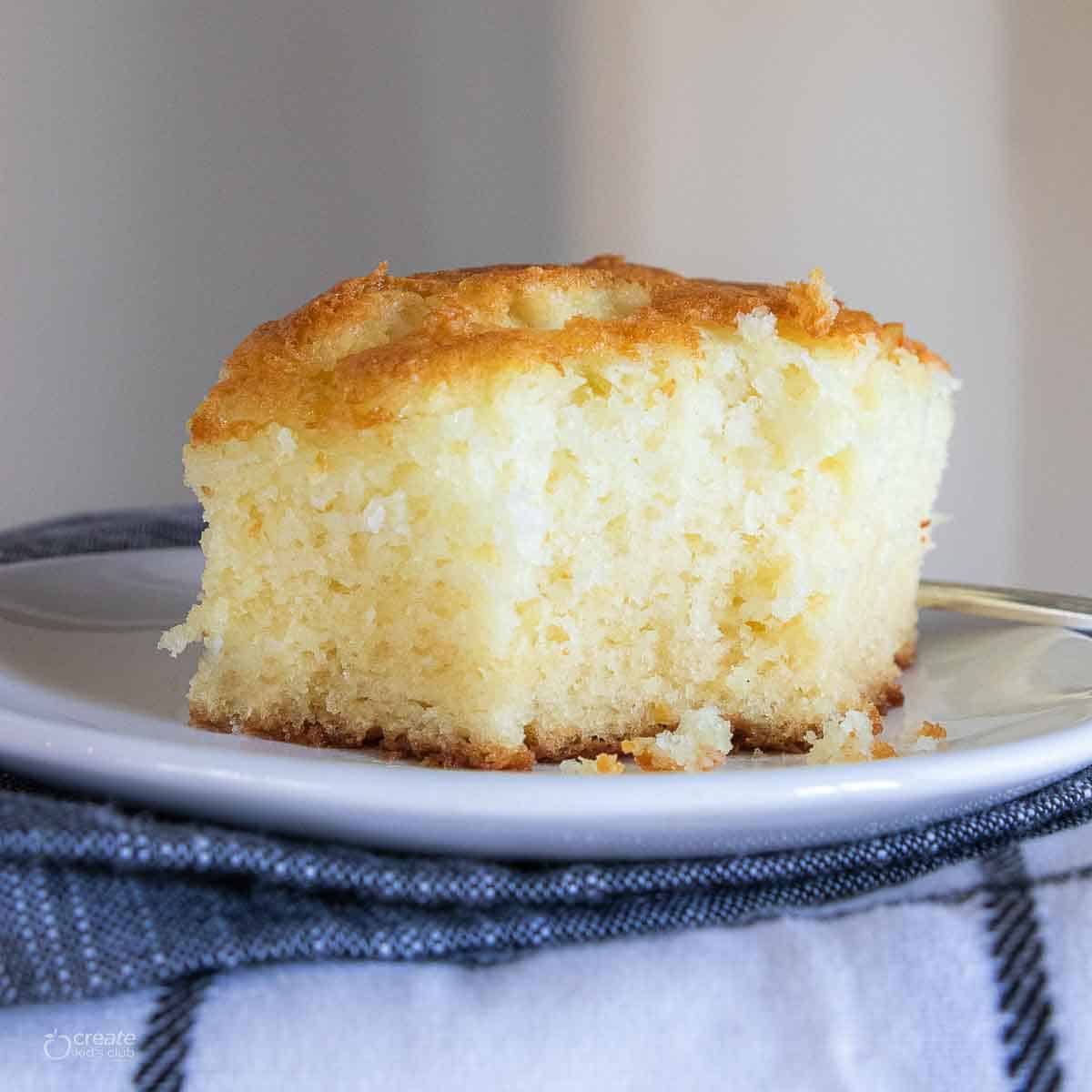 Gluten free cake cut into a square on a plate.