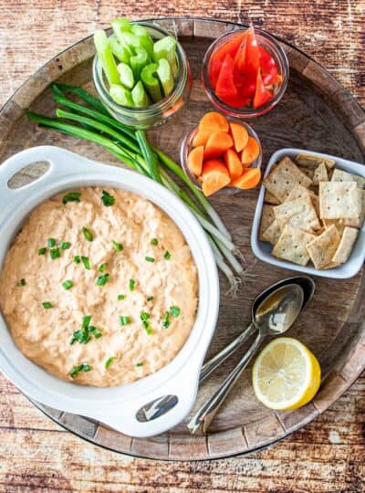 buffalo chicken on a serving tray with fresh veggies and crackers