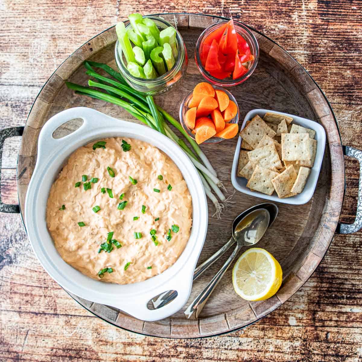 buffalo chicken on a serving tray with fresh veggies and crackers