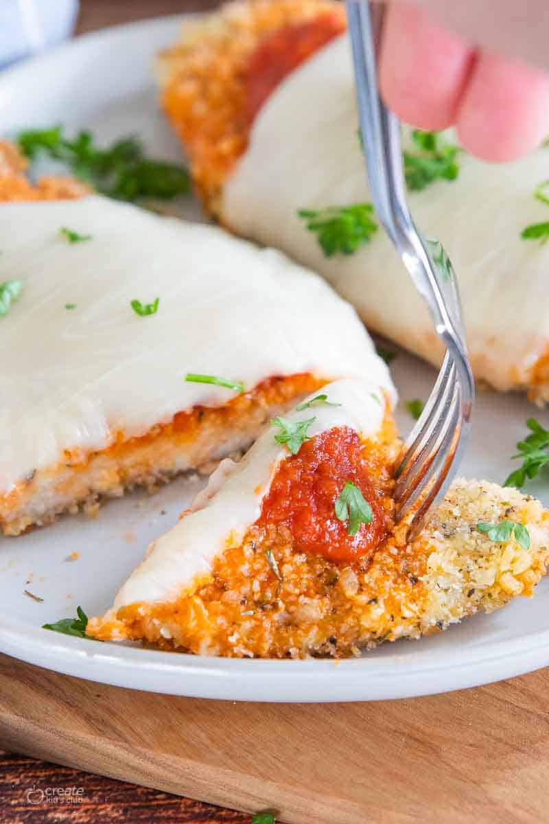 fork slicing a bite of gf chicken parm