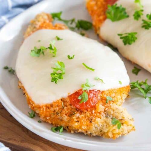 chicken parmesan on plate garnished with parsley
