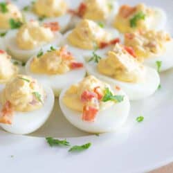 dairy free deviled eggs topped with bacon bits and herbs