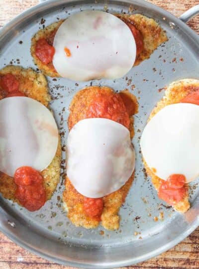 breaded chicken breasts topped with tomato sauce and provolone cheese slices