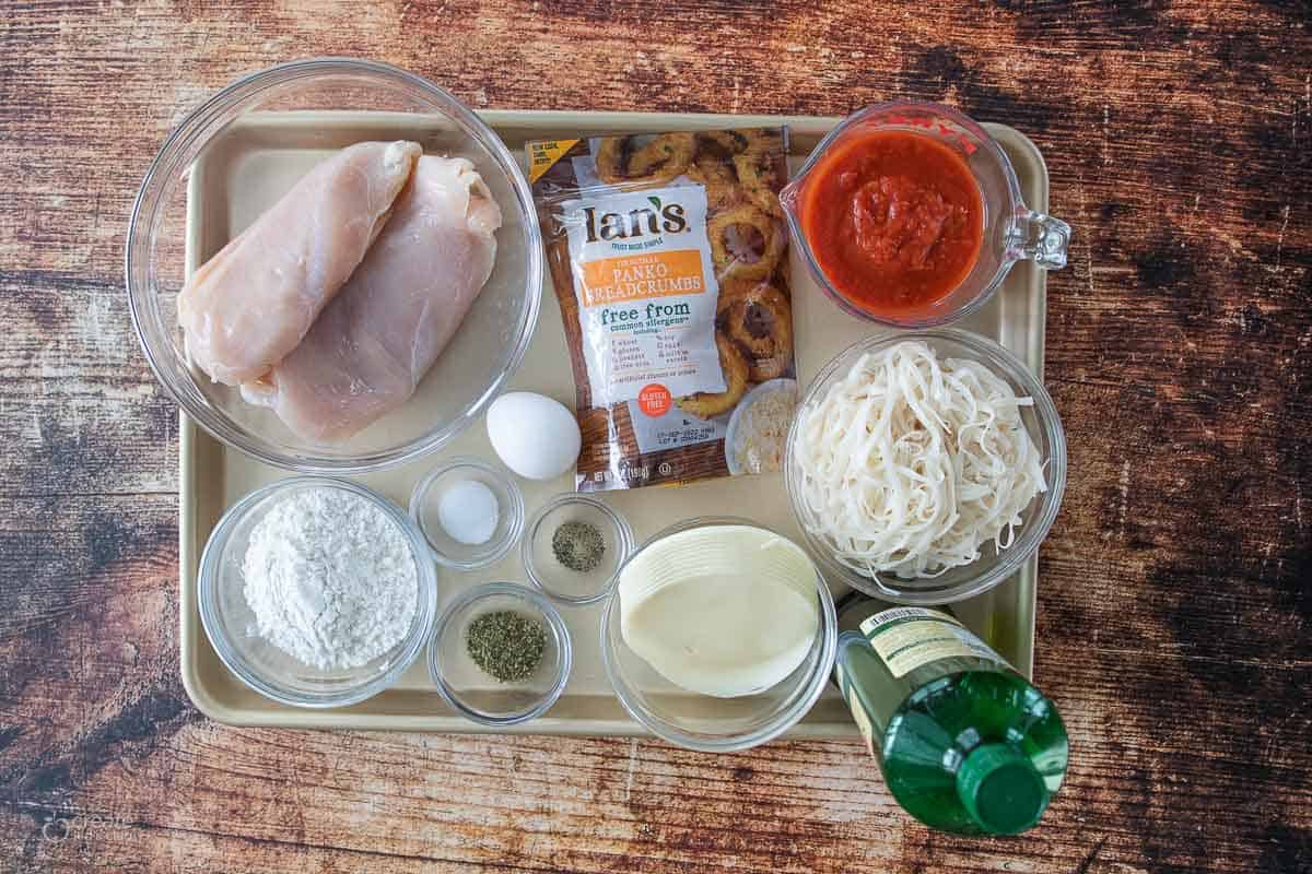 ingredients for chicken parmesan on baking sheet