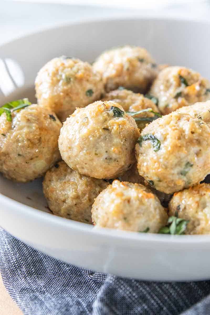 chicken meatballs garnished with fresh basil in serving bowl