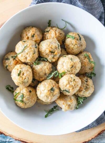 chicken meatballs garnished with fresh basil in serving bowl