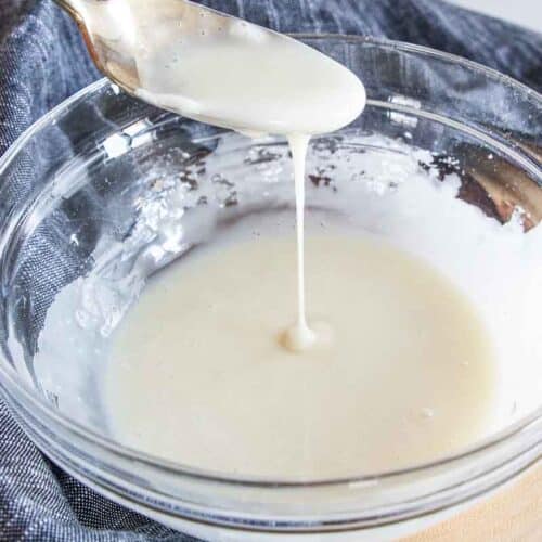 Gluten free icing spooned from a bowl.