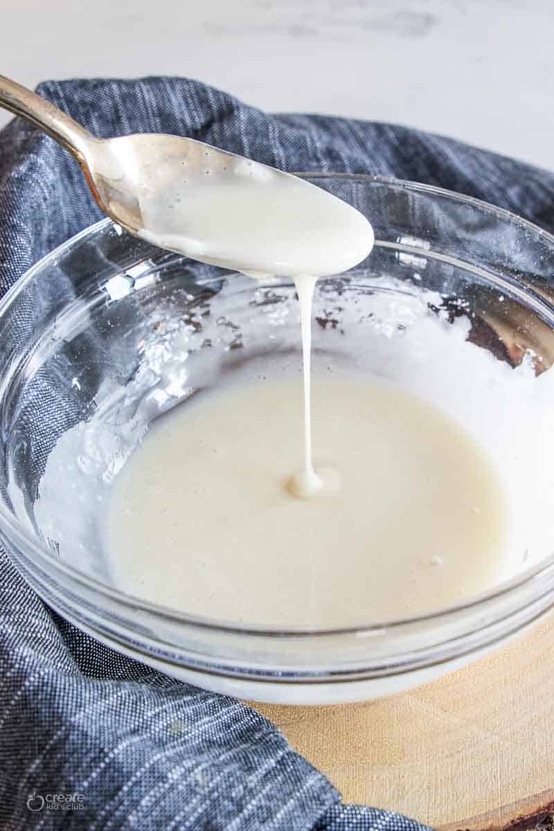Gluten free icing spooned from a bowl.