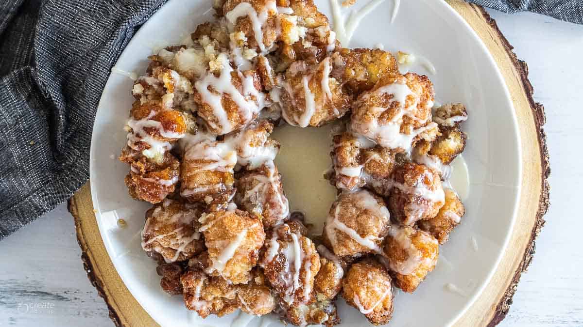 Gluten free icing topping monkey bread on a white plate.