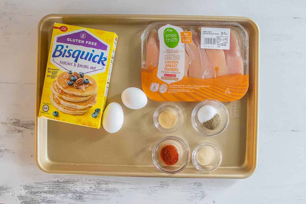 bisquick, eggs, chicken tenders and spices on sheet pan