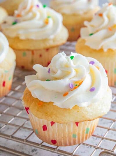 close view of frosted vanilla cupcake with sprinkles
