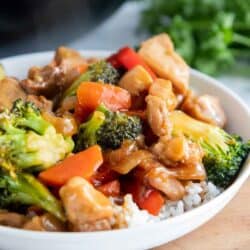 chicken stir fry served over white rice in bowl