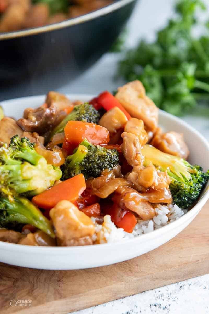 chicken stir fry served over white rice in bowl