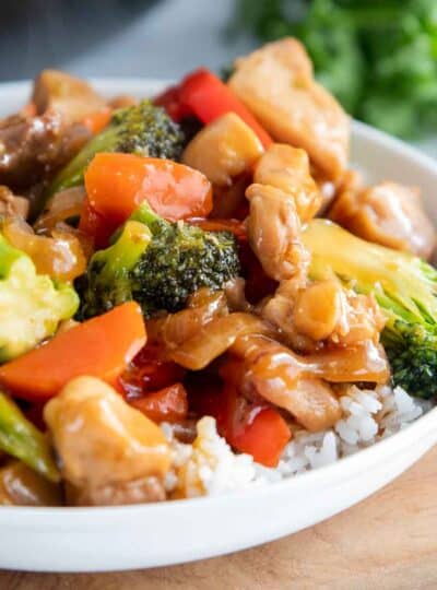 Chicken stir fry over rice in a bowl.