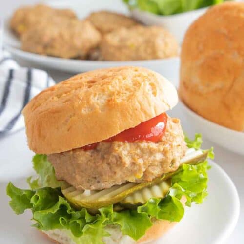 chicken burger with lettuce, pickles and ketchup