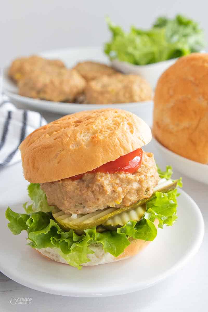 chicken burger with lettuce, pickles and ketchup