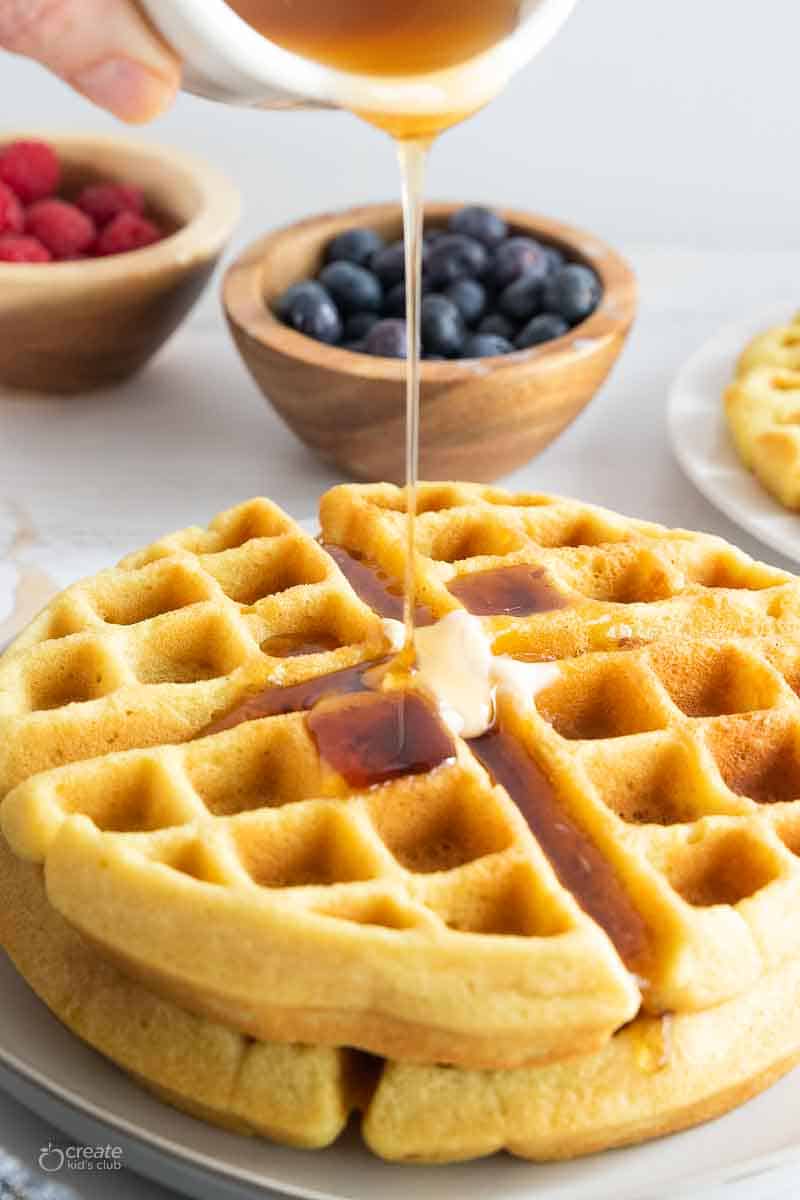 butter melted and syrup drizzled over stack of waffles