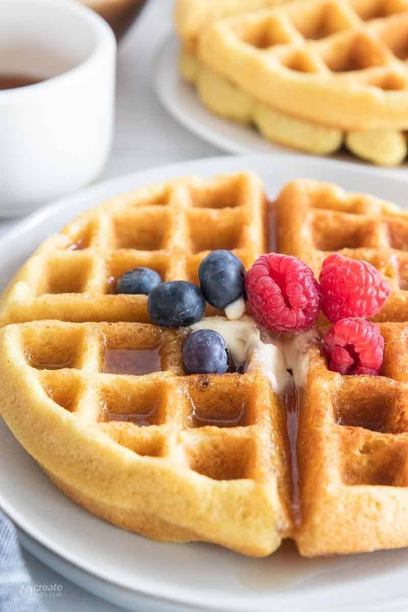 dairy free waffle on plate topped with berries