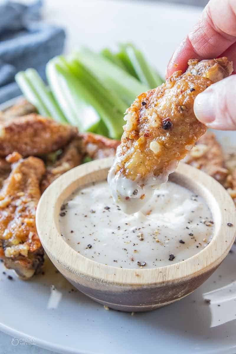 chicken wing dipped into sauce