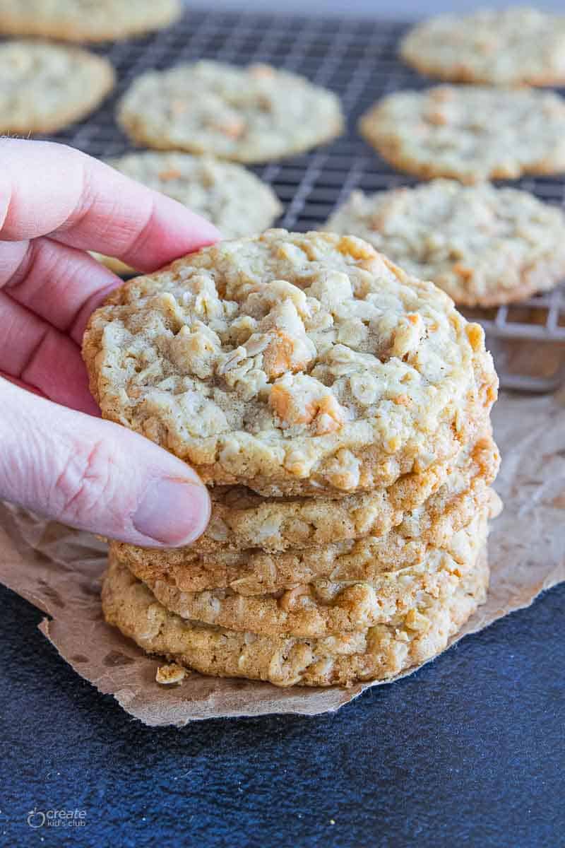 hand selecting oatmeal cookie from stack