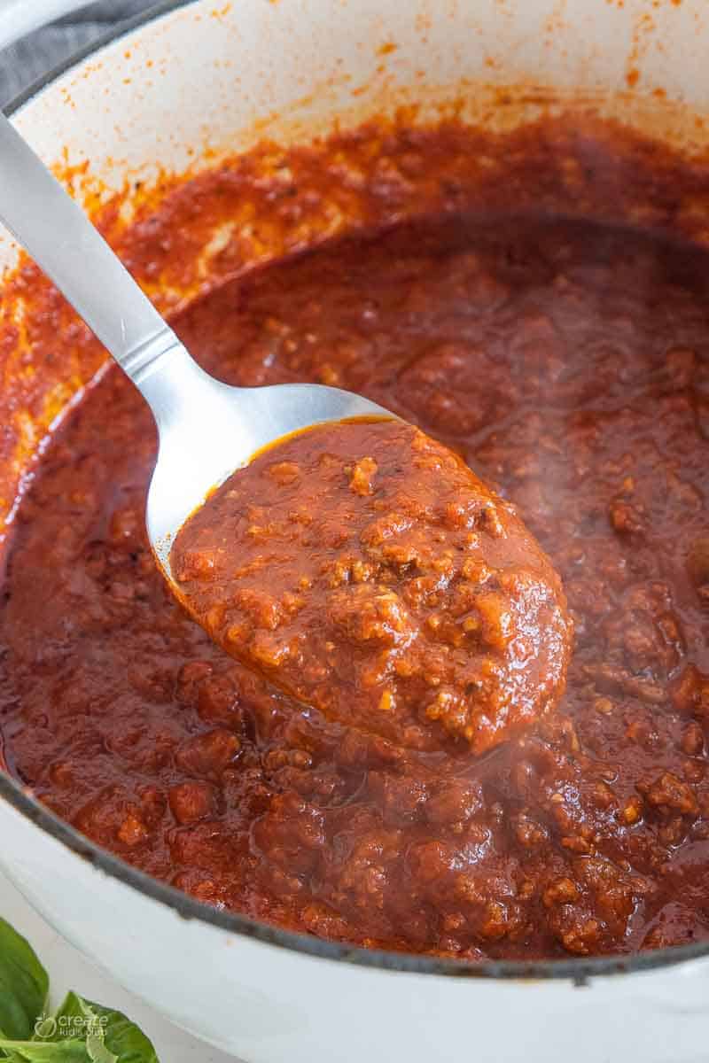 top view of spoon scooping pasta sauce from pot