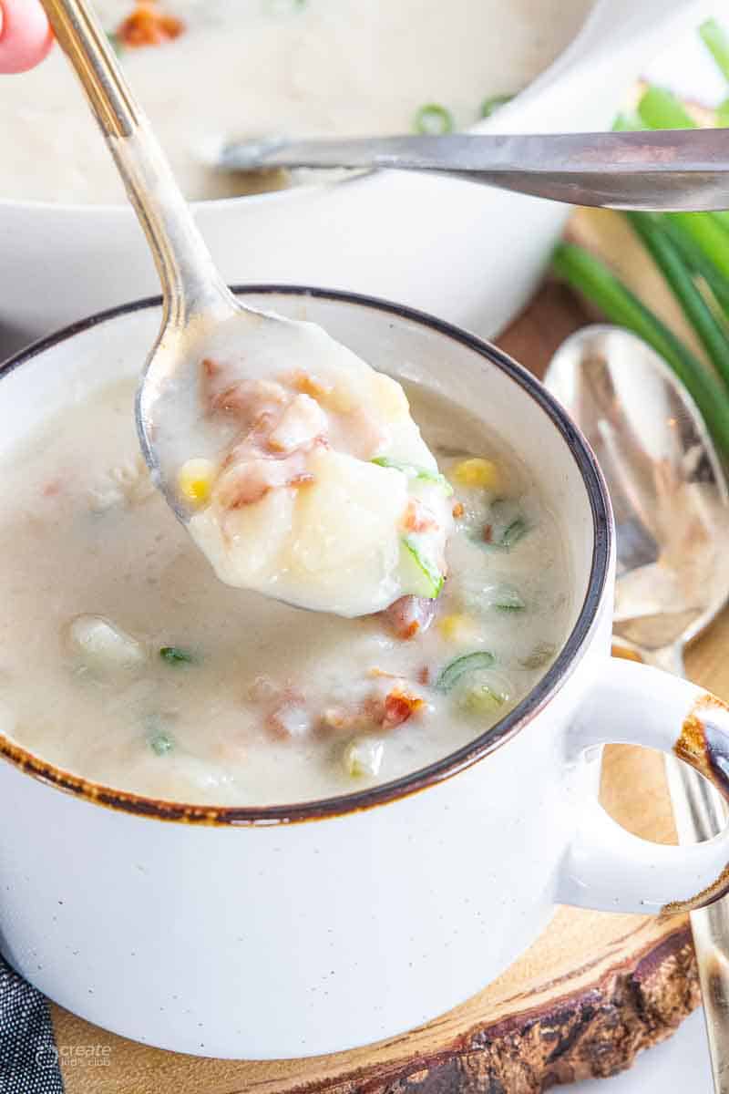 spoon scooping potato from soup mug