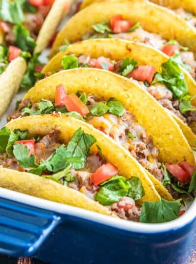 oven baked tacos with toppings in baking dish