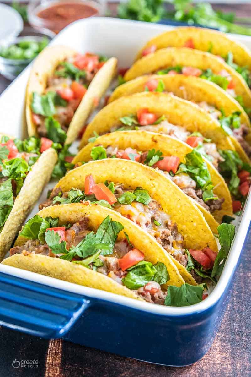 oven baked tacos with toppings in baking dish