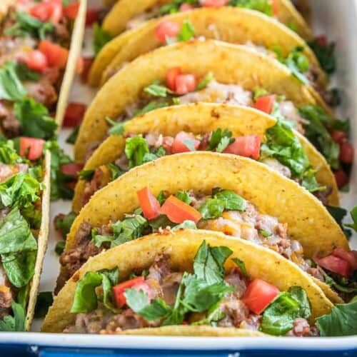 oven baked tacos with toppings in baking dish
