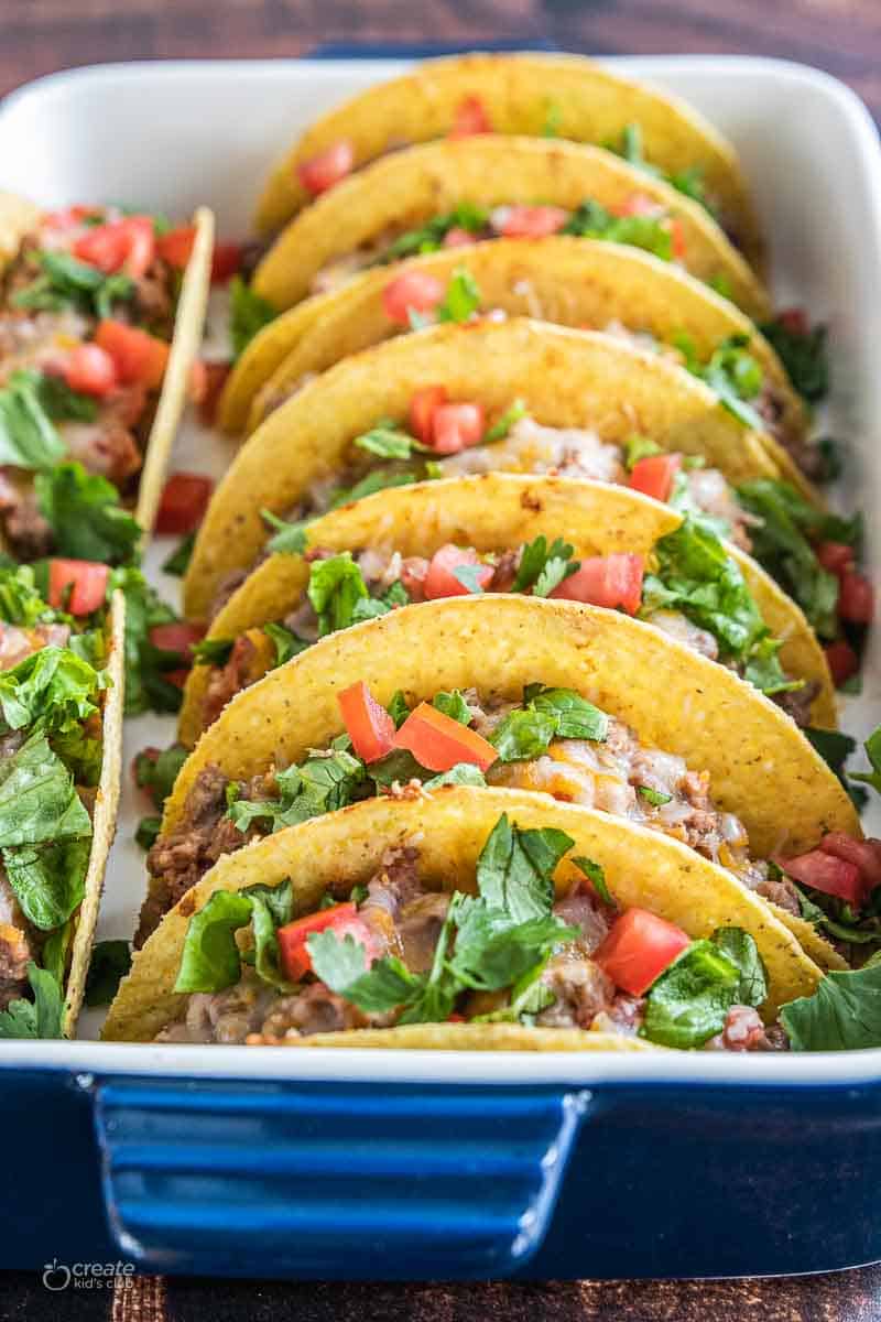 oven baked tacos with toppings in baking dish